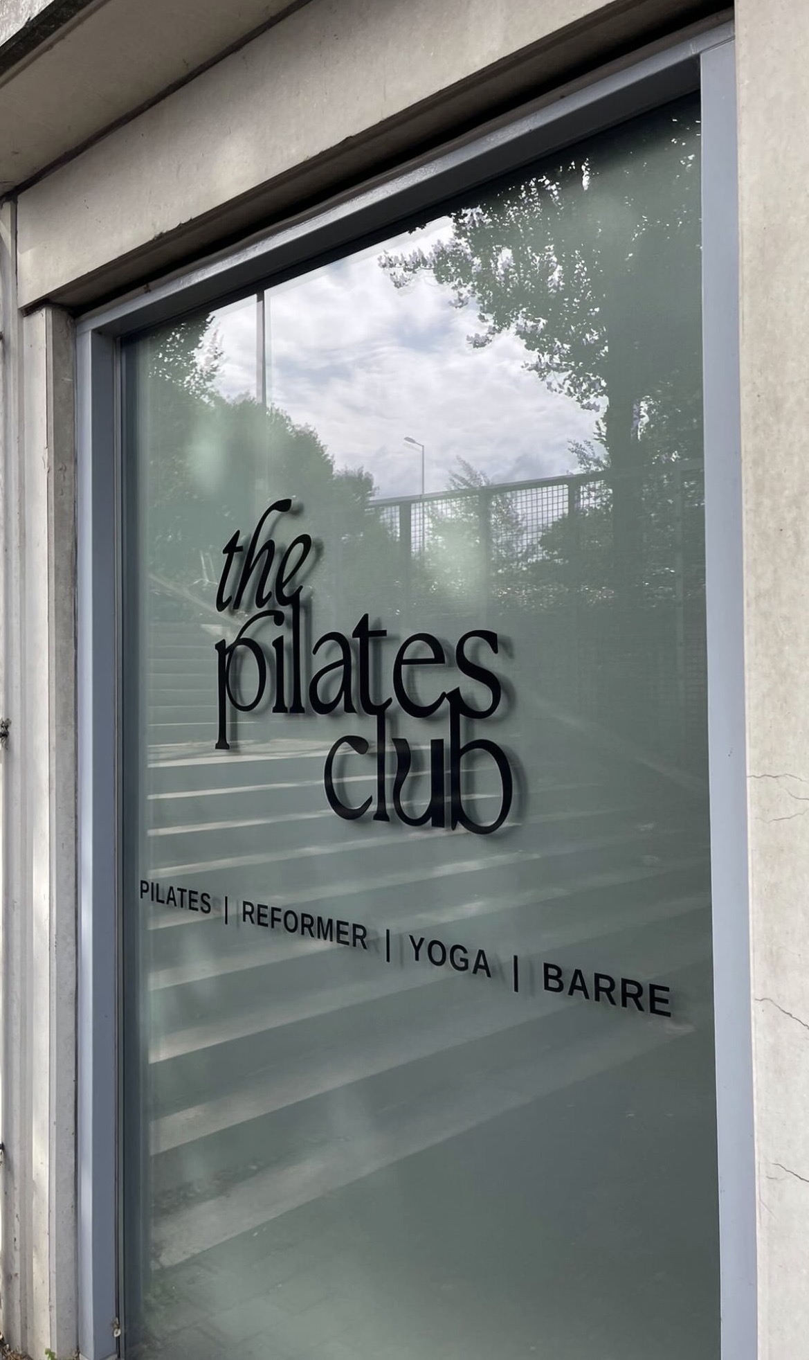 Raambestickering met The Pilates Club logo op etalageruit