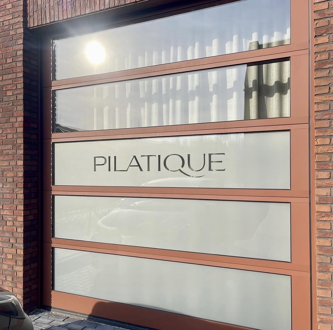 Raambestickering met Pilatique logo op etalageruit